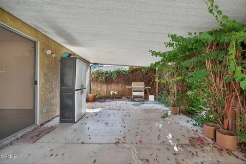 a view of a patio with table and chairs and a large tree