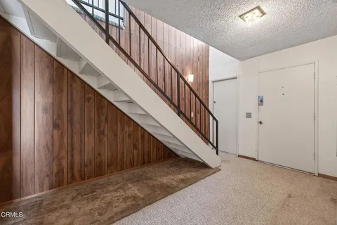 a view of staircase with wooden floor and white walls