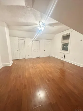 an empty room with fan and windows