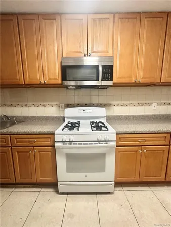 a stove top oven sitting inside of a kitchen