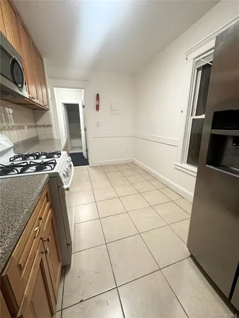 a kitchen with granite countertop a stove a sink and a microwave