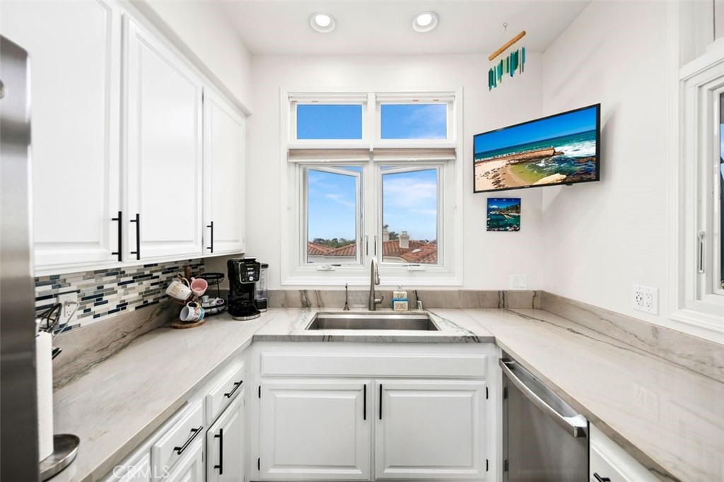 876 Cofair Court Solana Beach, CA 92075 - Photo 18 of 32 a kitchen with a sink cabinets and a window