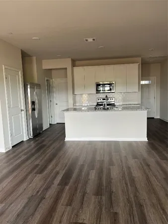 a view of a kitchen with a sink and a refrigerator