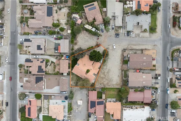 an aerial view of residential houses with outdoor space and parking