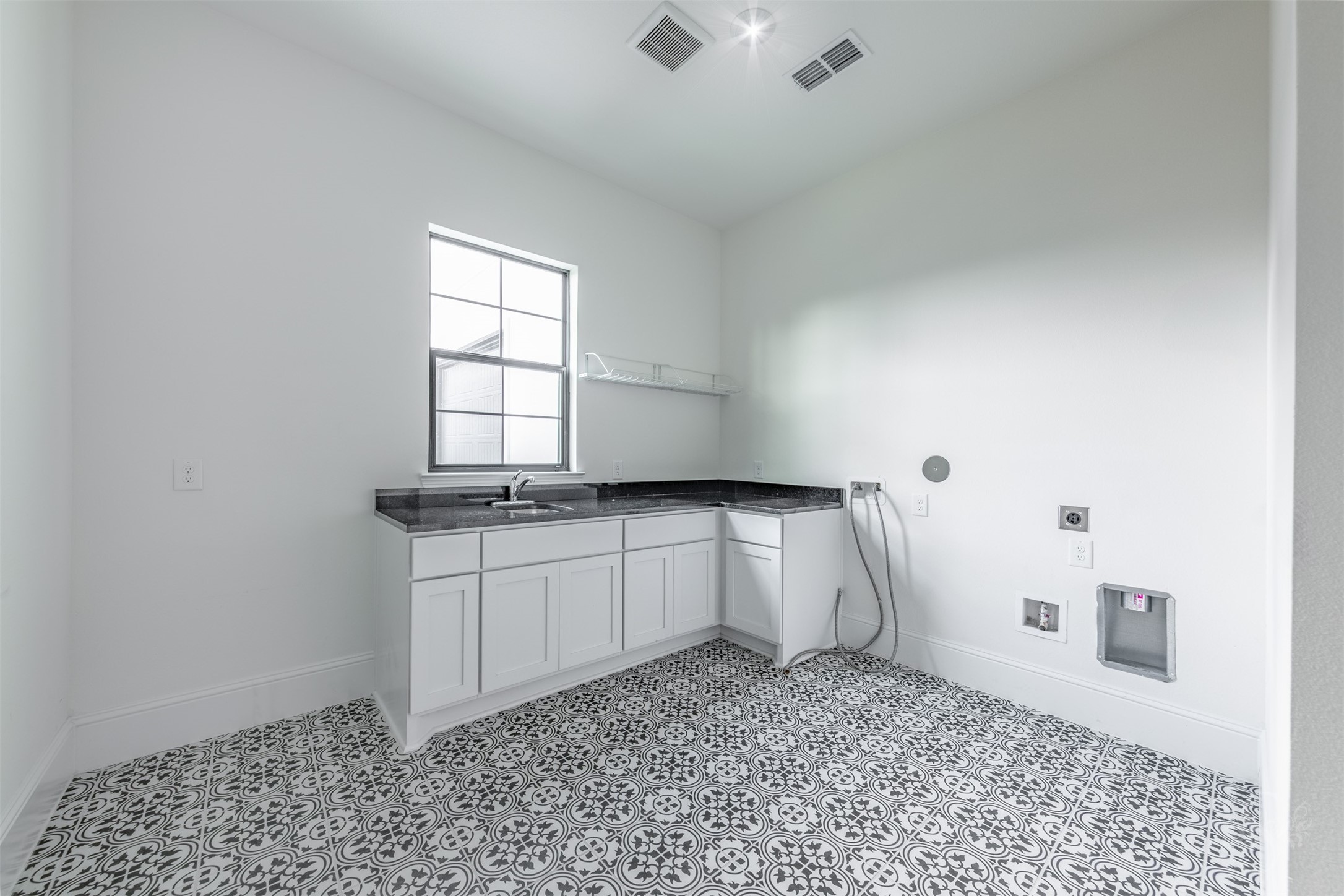 27919 Indigo Ridge Drive Fulshear, TX 77441 - Photo 23 of 50 The spacious laundry room includes expansive countertop space, a deep utility sink, abundant cabinetry, and room for an additional refrigerator or freezer. Designer tile flooring adds charm and personality to this impressive work space.
