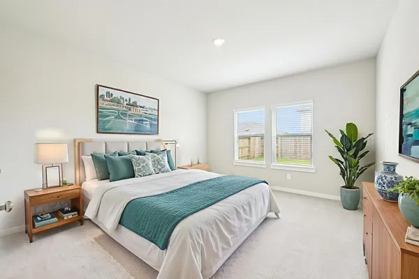 a bedroom with a large bed and a potted plant