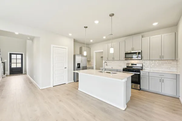 a large kitchen with cabinets and stainless steel appliances