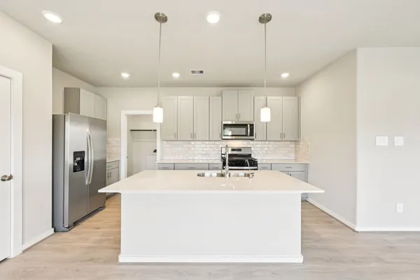 a kitchen with stainless steel appliances a refrigerator sink and microwave