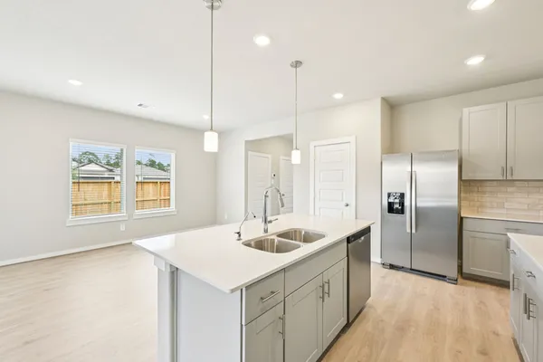 a kitchen with stainless steel appliances granite countertop a sink a refrigerator and a counter top space