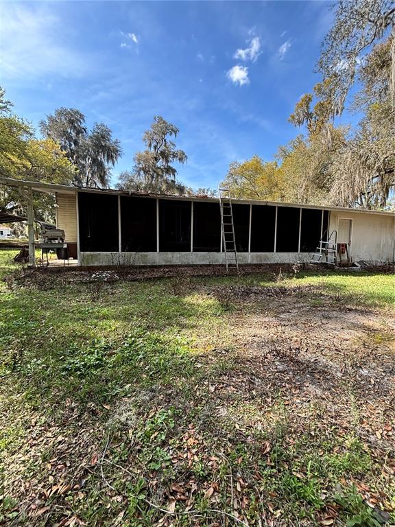 14179 Northeast 53rd Court Road Citra, FL 32113 - Photo 2 of 8 a front view of house with yard and trees in the background