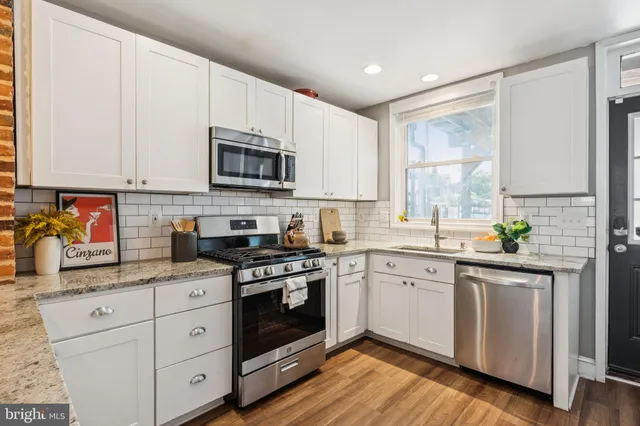 a kitchen with stainless steel appliances granite countertop a stove refrigerator and cabinets