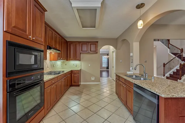 a kitchen with stainless steel appliances granite countertop a stove a sink and a microwave