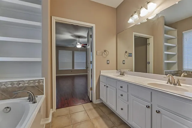 a spacious bathroom with a double vanity sink a large mirror and a shower
