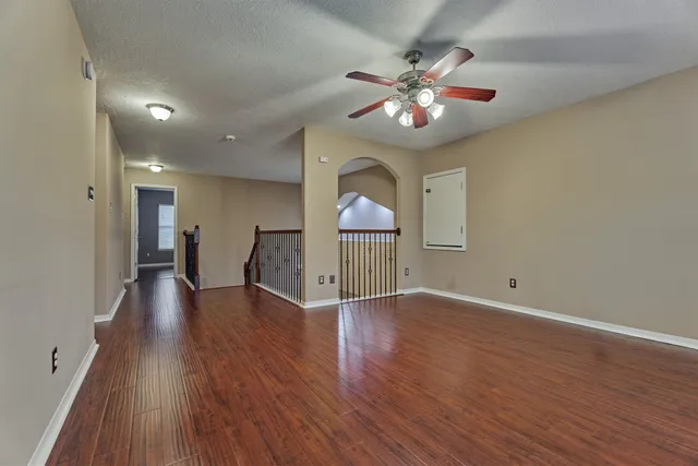 a view of a livingroom with a ceiling fan wooden floor and chandelier