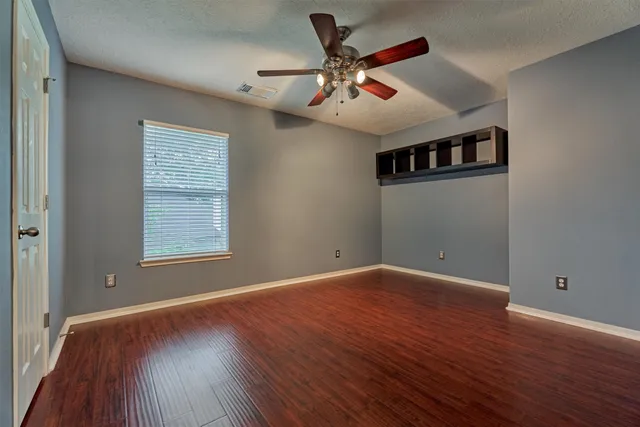 a view of empty room with wooden floor
