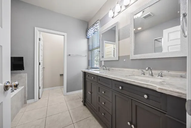 a spacious bathroom with a granite countertop sink and a mirror