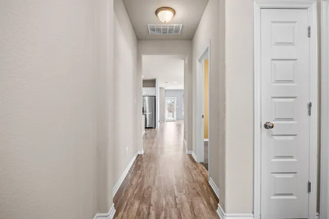 a view of a hallway with wooden floor