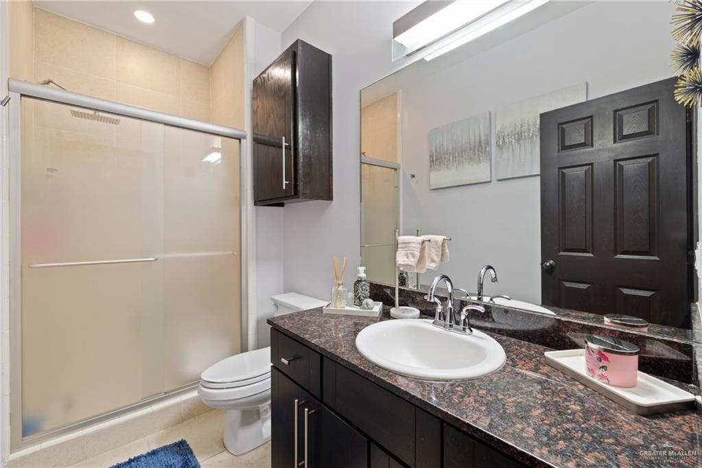 813 Travis Street, Unit 203 Mission, TX 78572 - Photo 15 of 30 a bathroom with a granite countertop sink toilet and shower