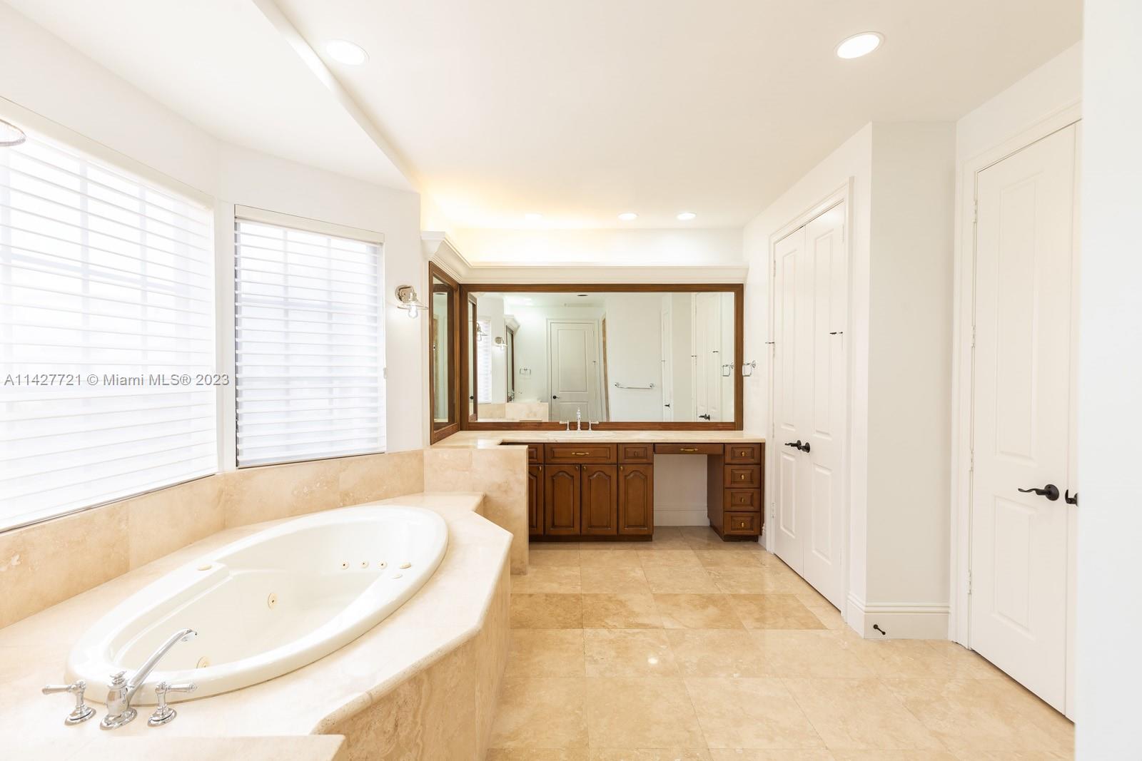 3471 Main Highway, Unit 928 Miami, FL 33133 - Photo 11 of 40 a bathroom with a tub a sink and a large window