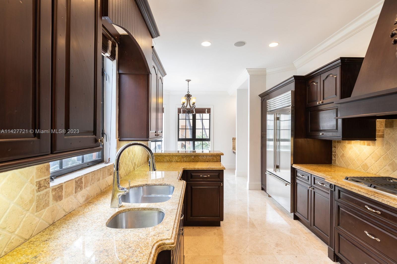 3471 Main Highway, Unit 928 Miami, FL 33133 - Photo 9 of 40 a kitchen with granite countertop a sink and a stove top oven