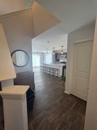 a living room with stainless steel appliances furniture a refrigerator and a kitchen view