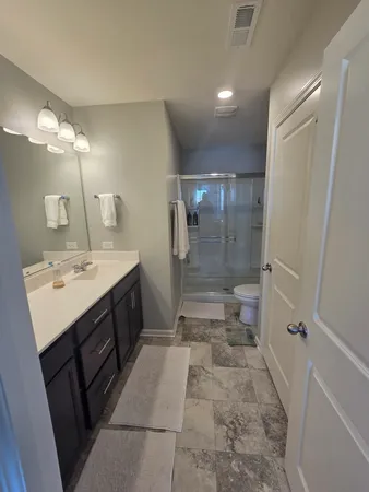 a bathroom with a sink a toilet and shower