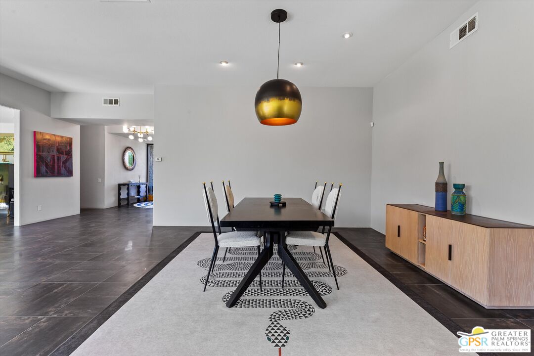 1075 East Suntan Lane Palm Springs, CA 92264 - Photo 12 of 39 a dining room with furniture a rug and a chandelier