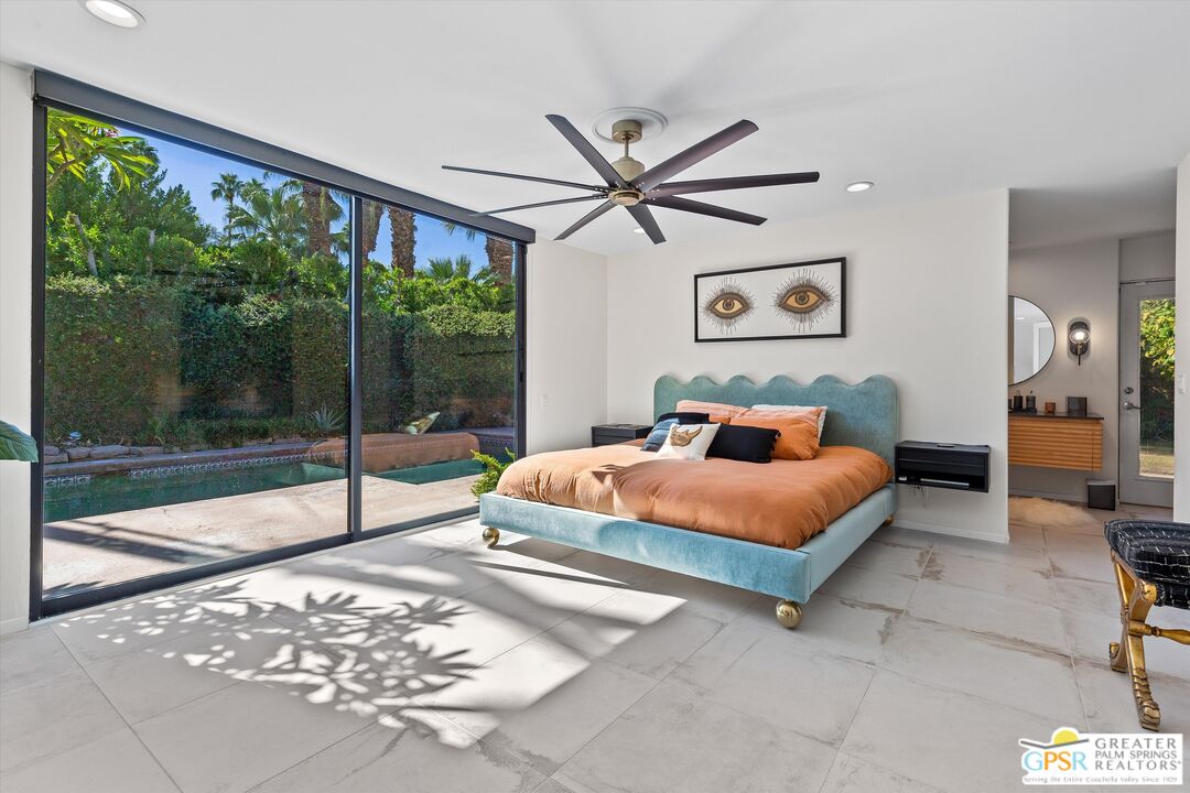1075 East Suntan Lane Palm Springs, CA 92264 - Photo 21 of 39 a bedroom with a large bed and a large window