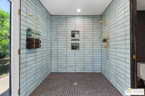 a bedroom with a bed dresser and a large window