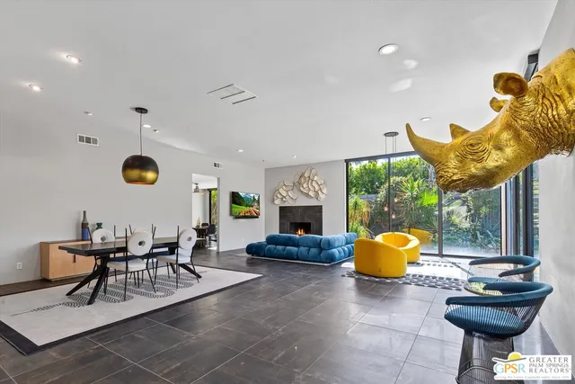 a living room with furniture a fireplace and a large window