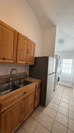 a kitchen with a sink a refrigerator and cabinets