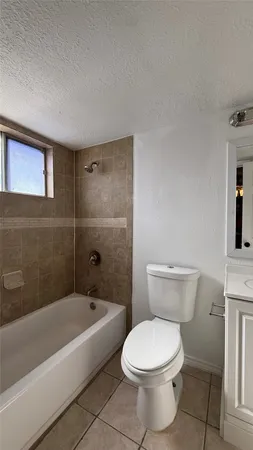 a white toilet and tub sitting next to a bathroom sink