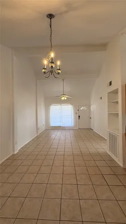 a view of an empty room with a chandelier
