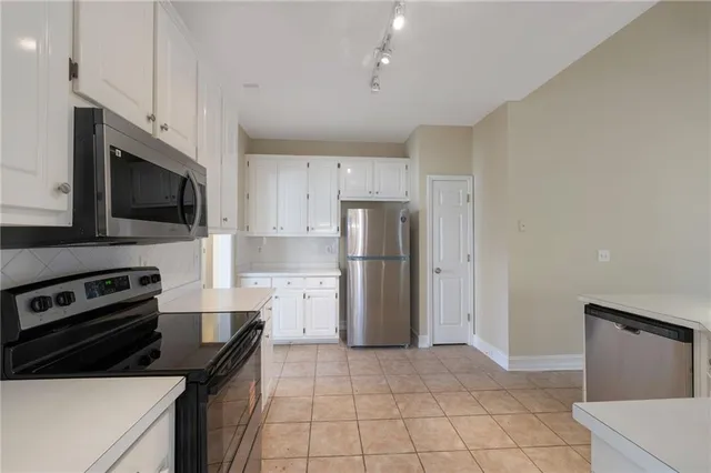 a kitchen that has a refrigerator a stove top oven a sink and dishwasher with wooden floor