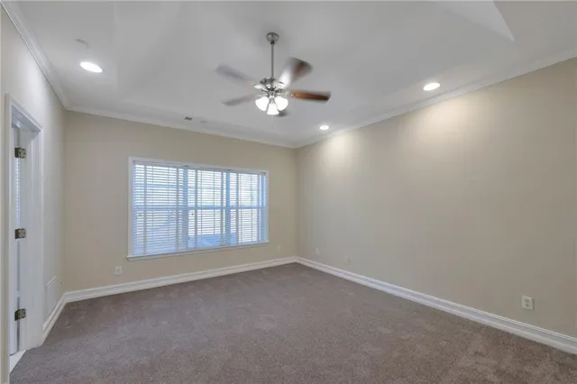 an empty room with chandelier fan and windows