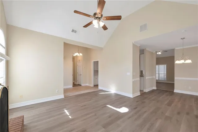 an empty room with wooden floor and a ceiling fan