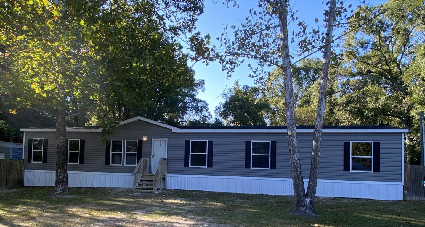 a front view of a house with a yard garage and wooden fence