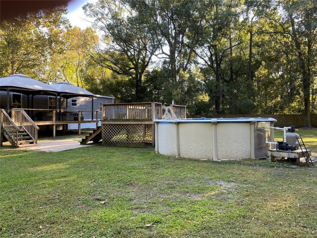 44079 Lee Drive Callahan, FL 32011 - Photo 11 of 32 a view of a yard with table and chairs a barbeque and large trees