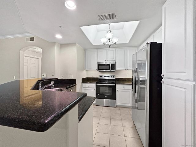 a kitchen with stainless steel appliances granite countertop a sink refrigerator and microwave