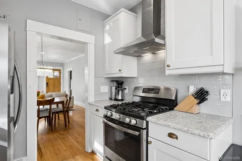 a kitchen with stainless steel appliances granite countertop a stove a sink and a refrigerator