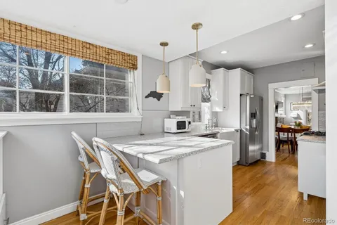 a kitchen with stainless steel appliances granite countertop a stove a refrigerator a oven a sink with a dining table and chairs