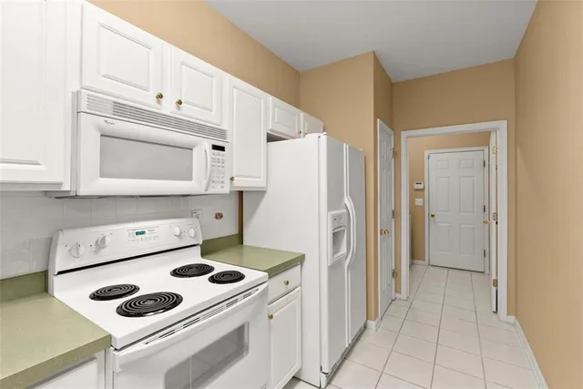 a kitchen with white cabinets and white appliances