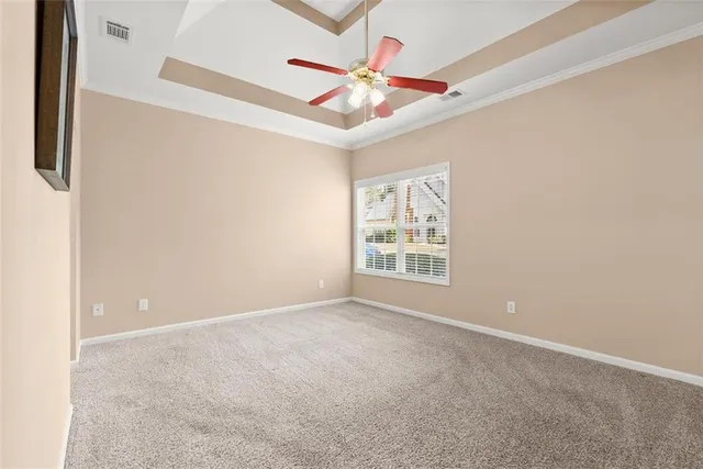 an empty room with ceiling fan and window