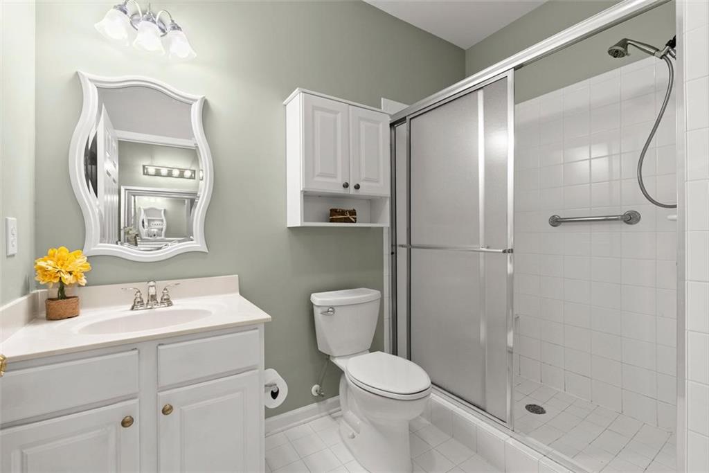 1225 Creek Forest Lane Austell, GA 30106 - Photo 17 of 32 a bathroom with a sink vanity mirror and toilet