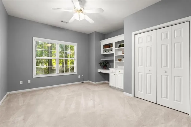 a view of a bedroom with cabinet and a ceiling fan