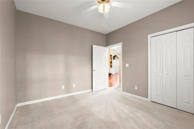 an empty room with a chandelier fan
