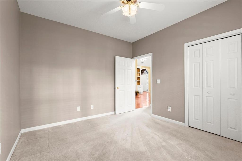 1225 Creek Forest Lane Austell, GA 30106 - Photo 25 of 32 an empty room with a chandelier fan