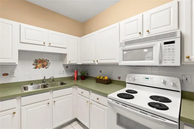 a kitchen with white cabinets and white appliances