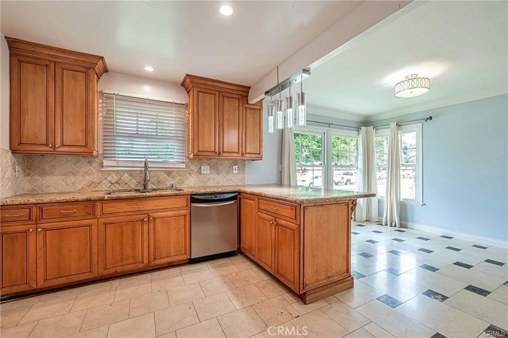 20129 Halsted Street Chatsworth, CA 91311 - Photo 7 of 31 a large kitchen with granite countertop a sink window and cabinets