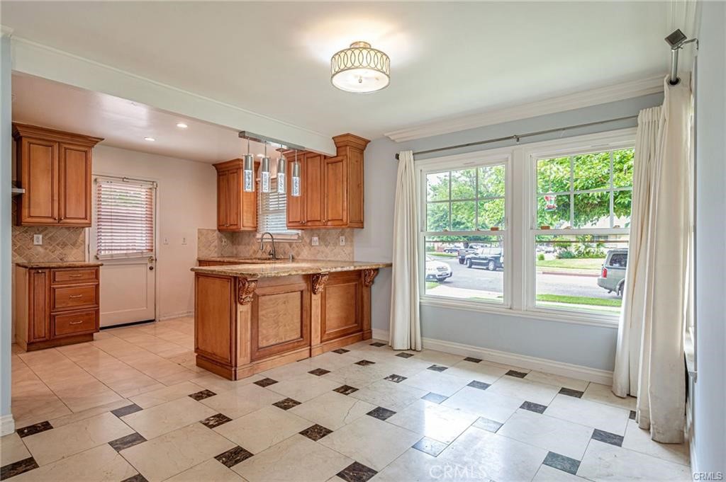 20129 Halsted Street Chatsworth, CA 91311 - Photo 10 of 31 a kitchen with granite countertop a sink a stove a refrigerator and cabinets
